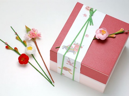 ユニ折箱 色かさね深緋、ほのか桜、帯紙ひな祭り、綾織ゴム若草16cmを使用しています