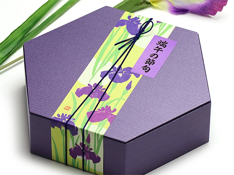 ユニ折箱 六角弁当　シンプルな菖蒲色の容器に季節の掛紙やシールを合わせてお使いいただくと、一層華やかになります。