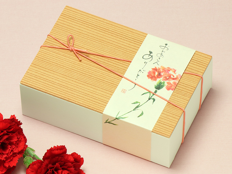 【使用アイテム】折箱：00-12330-101 ユニ折箱 白純 １合、飾りゴム：00-17403-404 花むすびゴム 紅梅（こうばい）12cm、掛紙：07-15302-560 帯紙 母の日 ありがとうカーネーション、造花：00-18502-300 造花 スプレイカーネーション 赤 新 を合わせたイメージ